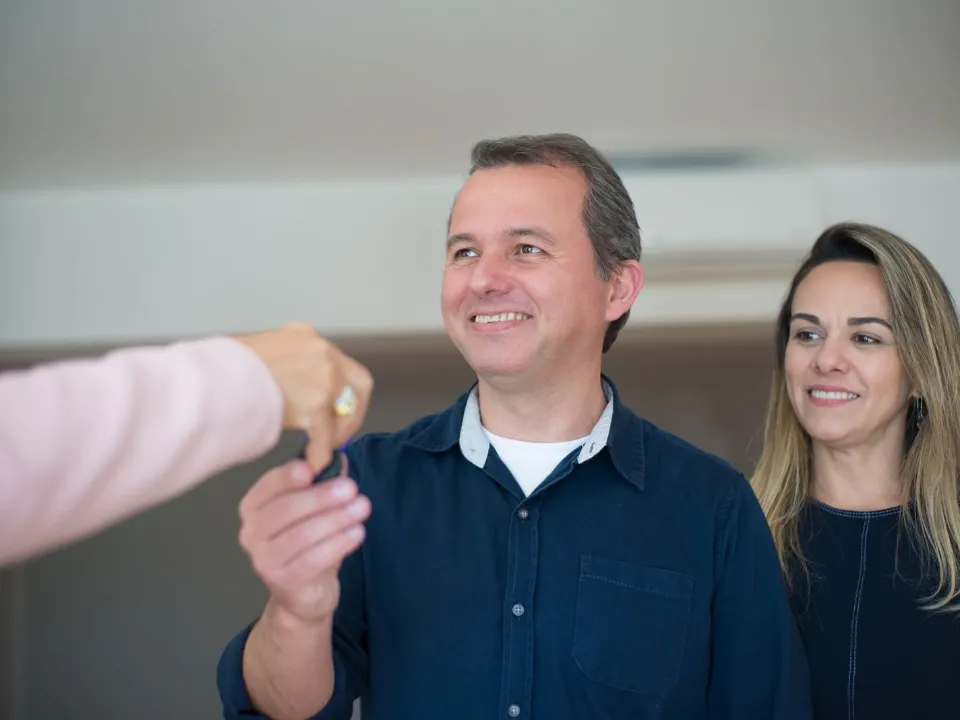 Casal recebendo a chave do imóvel