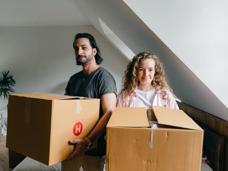 Casal segurando caixas de mudança na casa nova