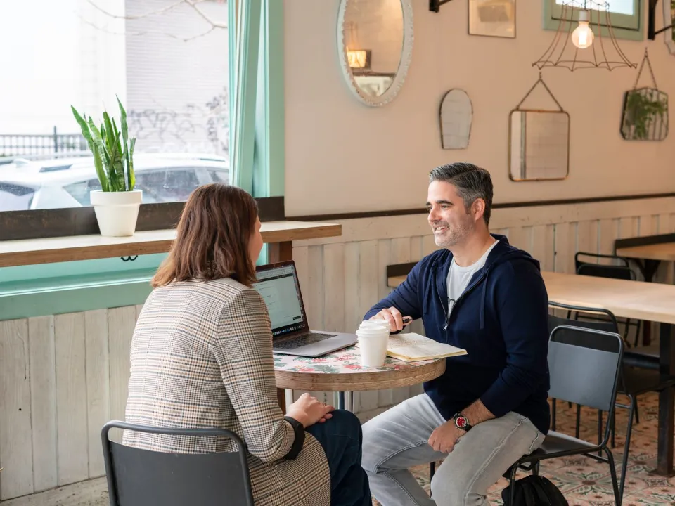 Dono de um café conversando com uma prestadora de serviço