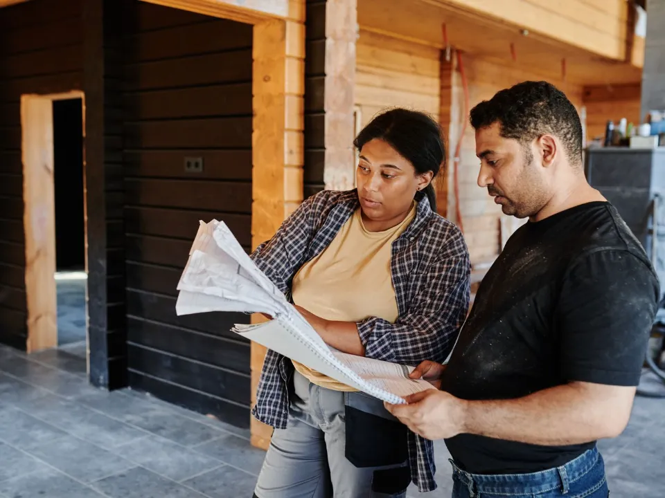 Moradora e prestador conferindo o projeto de uma obra