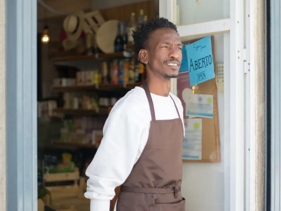 Comerciante na porta de um mercadinho
